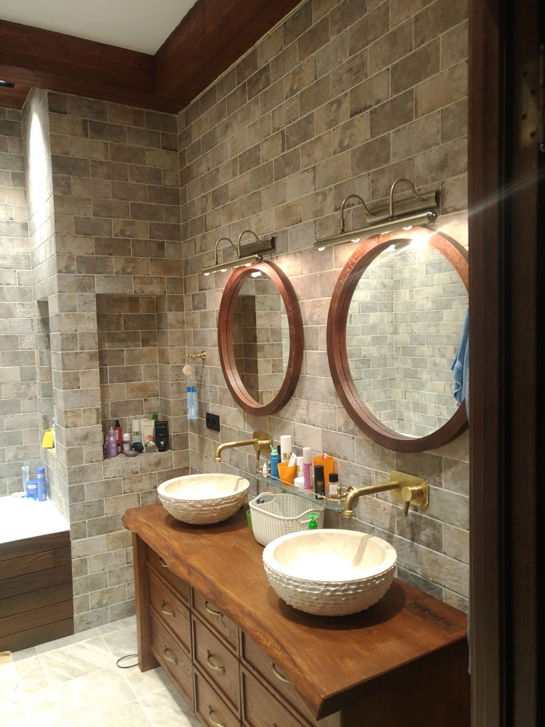 Круглое деревянное зеркало из массива дуба в интерьере ванной с двумя раковинами