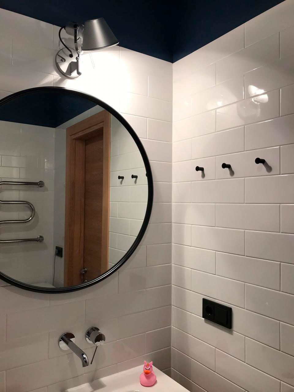 Черное зеркало в тонкой раме в интерьере ванной