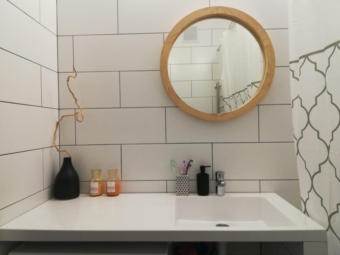 Круглое зеркало в деревянной раме из пихты в интерьере ванной в скандинавском стиле