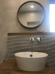 круглое зеркало в тонкой дубовой раме в ванной в интерьере