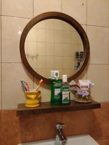Зеркало в раме с полкой в интерьере ванной
