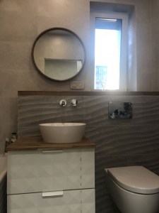 круглое зеркало в тонкой дубовой раме в ванной в интерьере