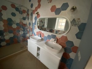 Зеркало капсула в белой раме в интерьере ванной