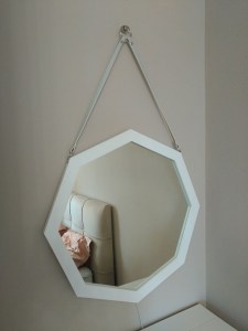 Белое зеркало октагон на ремне в интерьере спальни