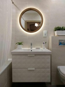 Зеркало с подсветкой в деревянной раме в интерьере ванной