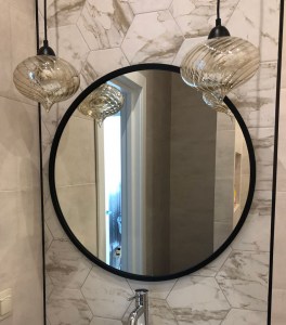 Круглое черное зеркало в интерьере ванной комнаты
