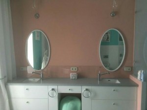 Овальное белое зеркало в раме из массива дуба в интерьере ванной