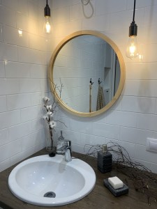 Зеркало в круглой деревянной раме из пихты в ванной