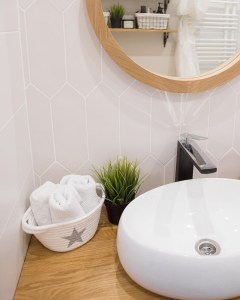 Круглое зеркало в раме из дуба в интерьере ванной в скандинавском стиле