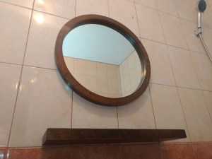 Круглое зеркало в коричневой раме из дуба с полкой