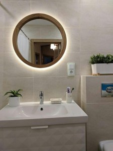 Зеркало с подсветкой в деревянной раме в интерьере ванной