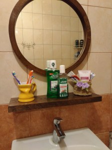 Зеркало в раме с полкой в интерьере ванной